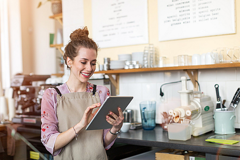 Junge Frau mit digitalem Tablet im Café