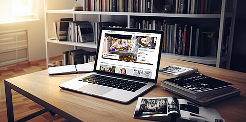 Ein Laptop auf einem Schreibtisch in einem Büro zeigt die Startseite des BGN-Webmagazins Akzente