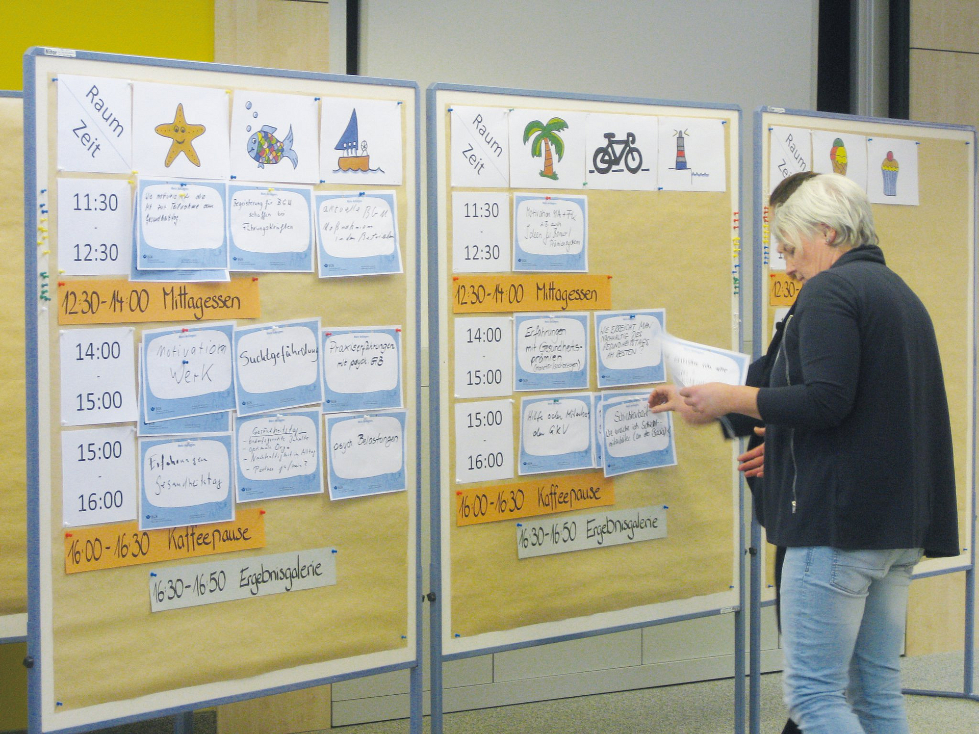 Zwei Mitarbeiterinnen stehen vor einer Pinnwand beim Barcamp 2019.