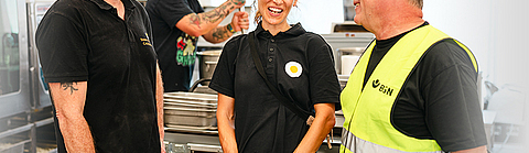 Paul Cusack und Clara Seipp von Sunny Side Catering im Austausch mit BGN-Arbeitsschutzexperte Stephan Thomassohn.