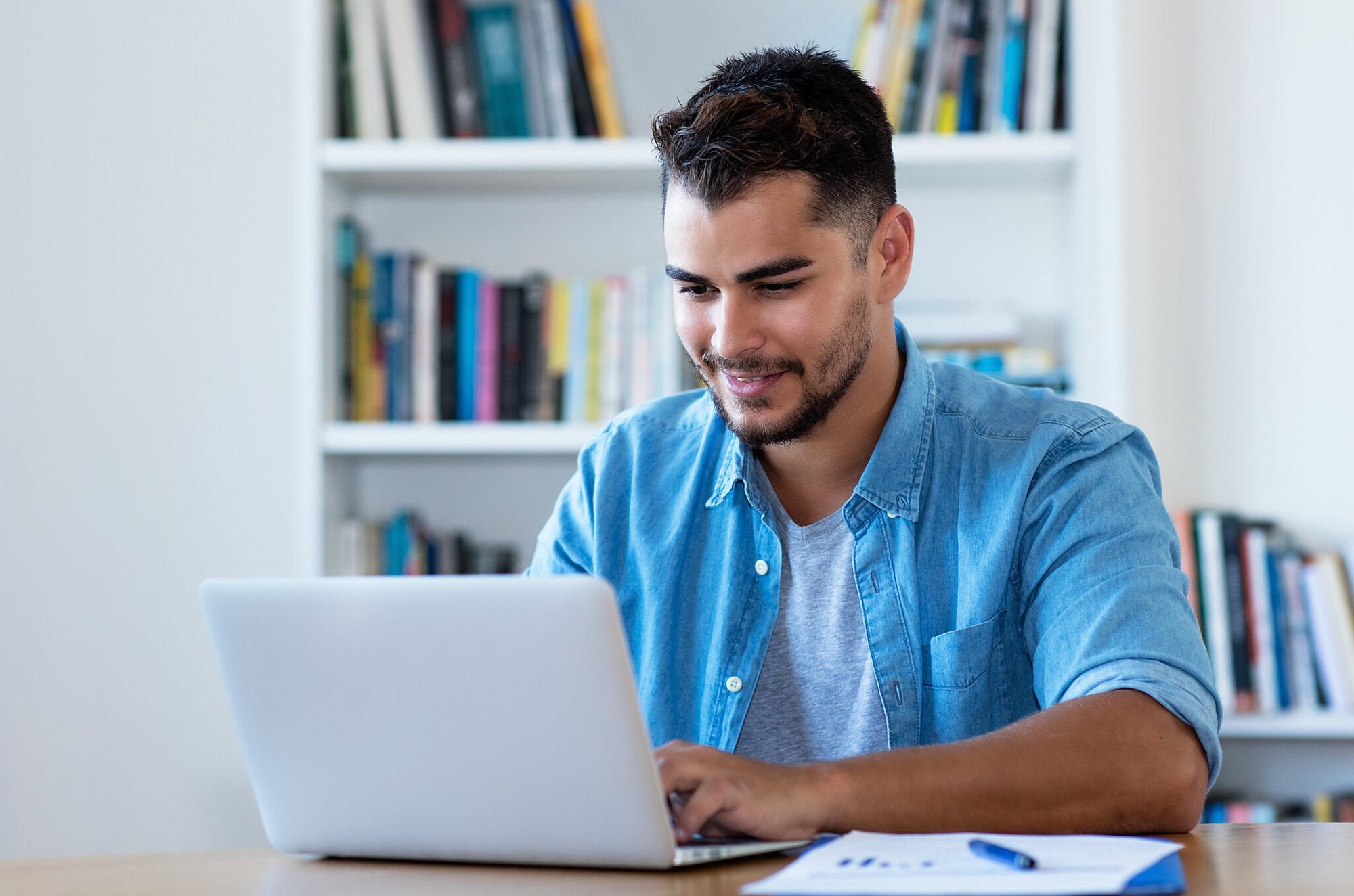 Junger Mann arbeitet am Laptop