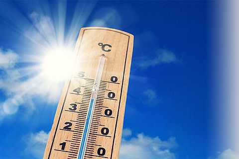 Ein Thermometer vor einem blauen Himmel mit Sonne zeigt über 30 Grad Celsius an.