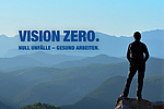 Eine Person steht auf einem Berg und schaut in die Weite. Im Berg ist das Logo für "VISION ZERO".