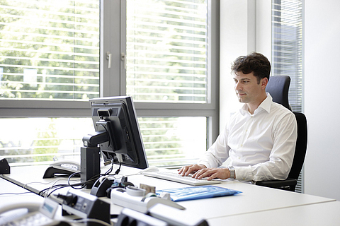 Büroangestellter sitzt am Computer