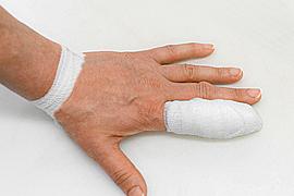 Ein Hand, der Zeigefinger ist mit Verband umwickelt.
