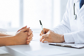 Arzt macht sich Notizen währen eines Patientengesprächs