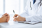 Arzt macht sich Notizen währen eines Patientengesprächs