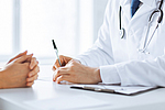 Arzt macht sich Notizen währen eines Patientengesprächs