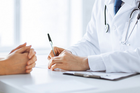 Arzt macht sich Notizen währen eines Patientengesprächs