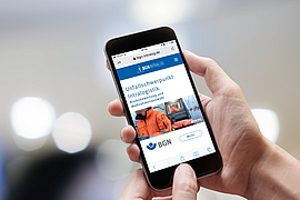 Hände halten ein Smartphone auf dem die BGN-App Intralog angezeigt wird.