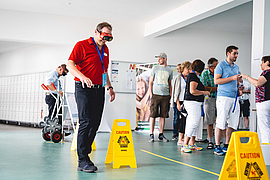 Bei einem Gesundheitstag macht ein Mitarbeiter einen Parcours mit einer besonderen Brille.