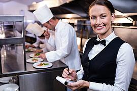 Lächelnd Kellnerin mit Notizblock in Großküchen