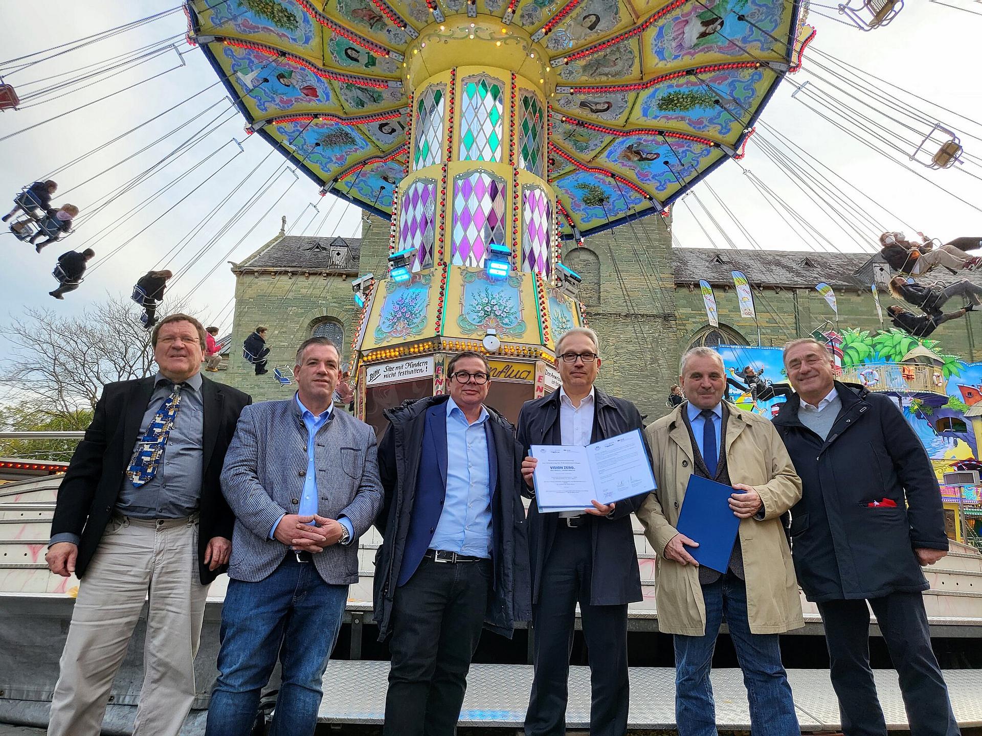 Werner Hammerschmidt, Hansi Luxem, Patrick Arens, Jürgen Schulin, Albert Ritter , Thomas Schneider stehen mit unterzeichneter Kooperation vor einem Karussell.