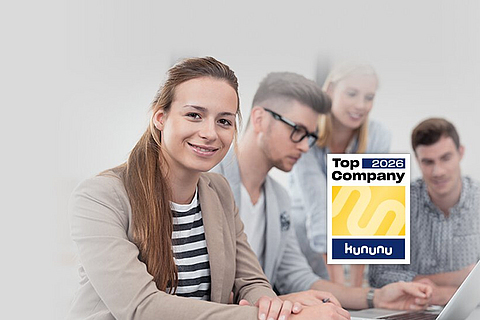 Zwei Schüler und zwei Schülerinnen sitzen am Tisch und lernen, im Vordergrund das kununu Top Company Logo