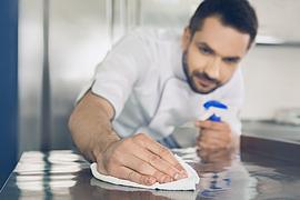 Ein Koch reinigt eine Oberfläche in der Küche