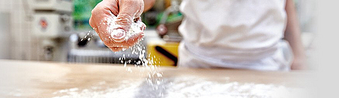 Mehl wird auf einen Tisch verteilt.