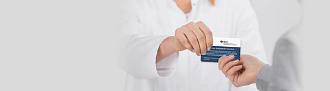 Patientin überreicht Versicherungskarte der BGN.