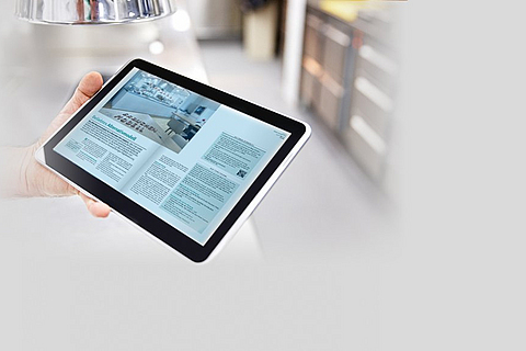 Die neueste Ausgabe von Report auf einem Tablet