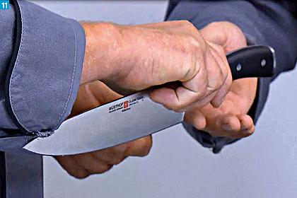Ein Messer wird mit dem Griff voran einer anderen Person weitergereicht.