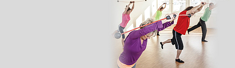 mehrere Personen bei Rückengymnastik-Übungen in einer Sporthalle