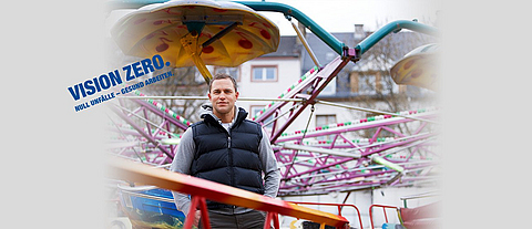 Ein Schausteller steht vor seinem Fahrgeschäft.