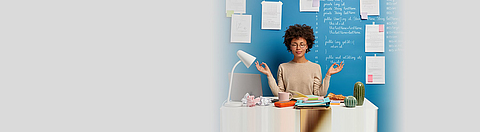 Frau am Arbeitsplatz entspannt sich mit Yoga-Pose