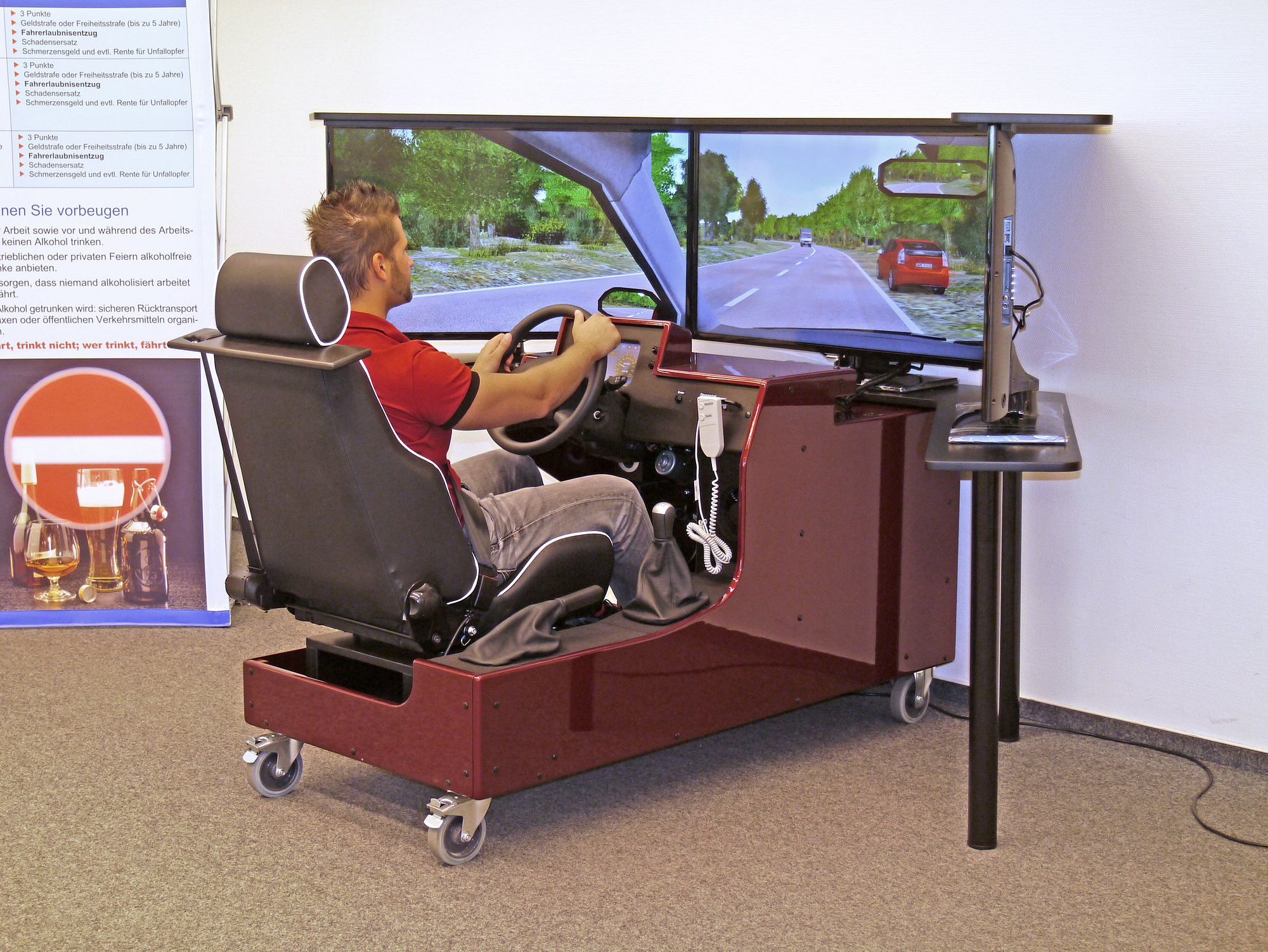 Mann sitzt in ein Fahrsimulator und macht eine Testfahrt
