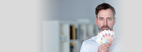 Unternehmer hält Euroscheine in der Hand