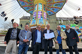 Werner Hammerschmidt, Hansi Luxem, Patrick Arens, Jürgen Schulin, Albert Ritter , Thomas Schneider stehen mit unterzeichneter Kooperation vor einem Karussell.
