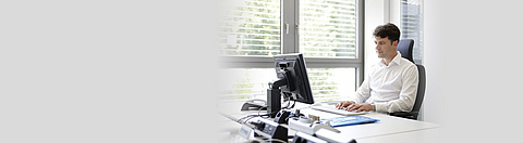 Büroangestellter arbeitet an einem Schreibtisch