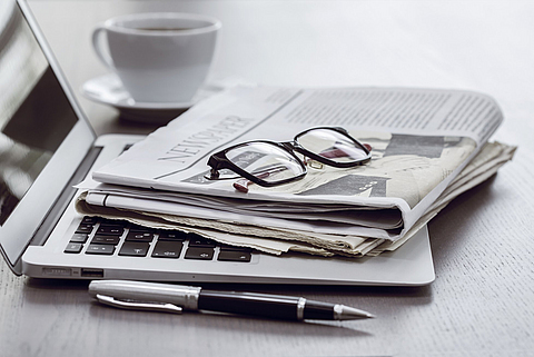 Zeitung mit Computer auf dem Tisch