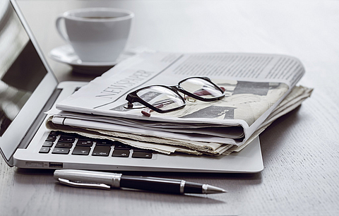 Zeitung mit Computer auf dem Tisch