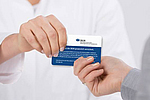 Patientin überreicht Versicherungskarte der BGN.