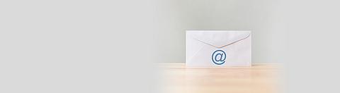 Briefumschlag mit Symbol e-Mail-Adresse auf einem Holztisch