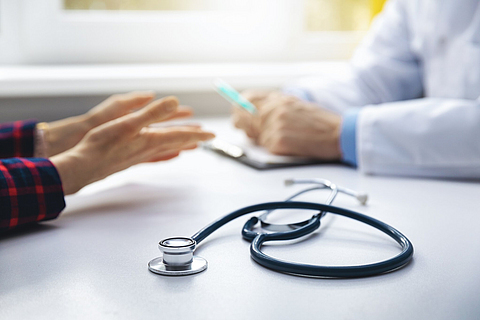 Medizinische Beratung - Arzt im Gespräch mit Patienten in der Arztpraxis. Im Fokus das Stethoskop