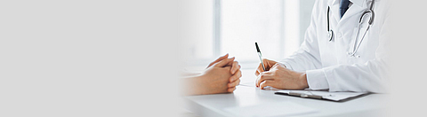 Arzt macht sich Notizen während eines Patientengesprächs