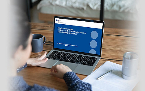 Eine Person sitzt vor einem Notebook und nimmt an einem Onlinemeeting teil