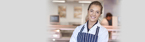 Junge Fleischereifachverkäuferin in einer Metzgerei