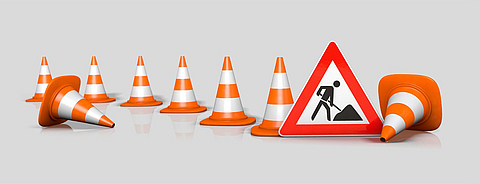 Wartungsarbeiten verdeutlicht durch ein Baustellenwarnschild und Bauhütchen.