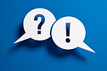 Fragezeichen- und Ausrufezeichen-Sprechblasen vor einer blauen Wand