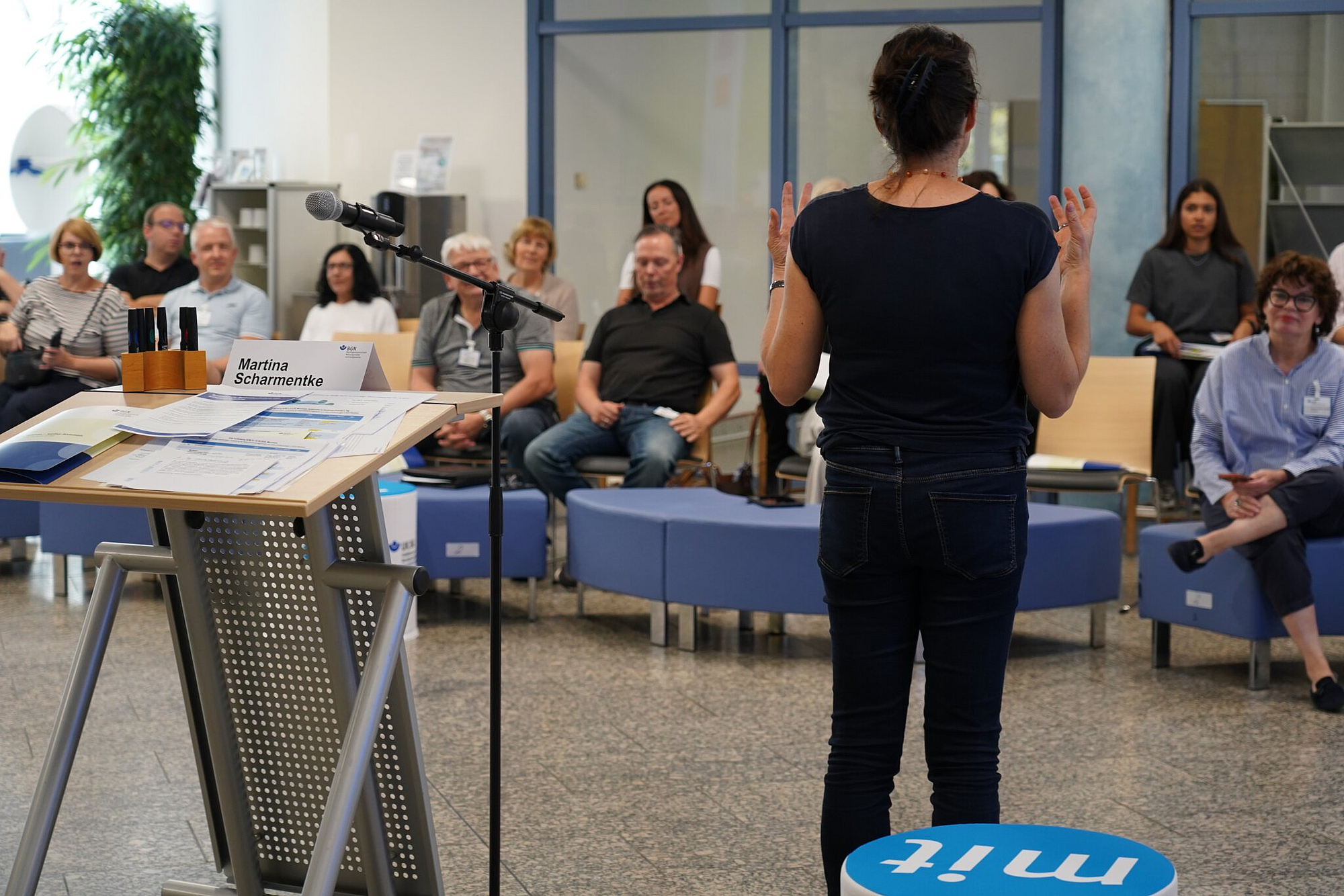 Gesundheitsmanager sichten Infomaterialien und unterhalten sich darüber an einem Tisch.