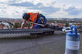 Mann in Rückhaltesystem an Absturzkante