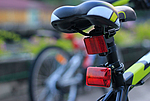 Ein Fahrradsattel in der Nahaufnahme mit roten Reflektoren an der Sattelstange
